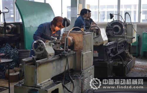 图为工作人员在生产车间现场加工矿山机械产品零件.